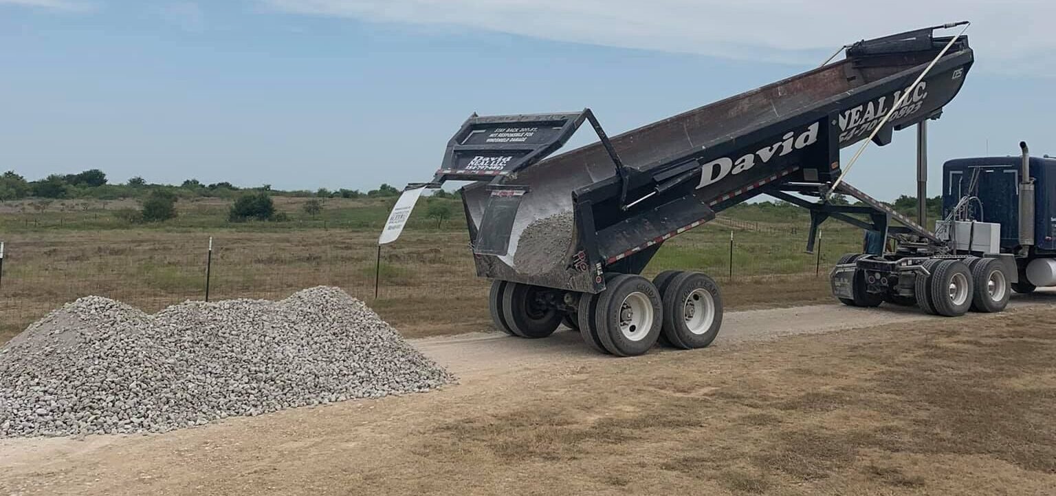 Rear dump truck dropping road base "coliche" to resurface a road ~ David Neal Trucking