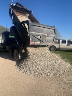 Rear dump truck dropping gravel for a road